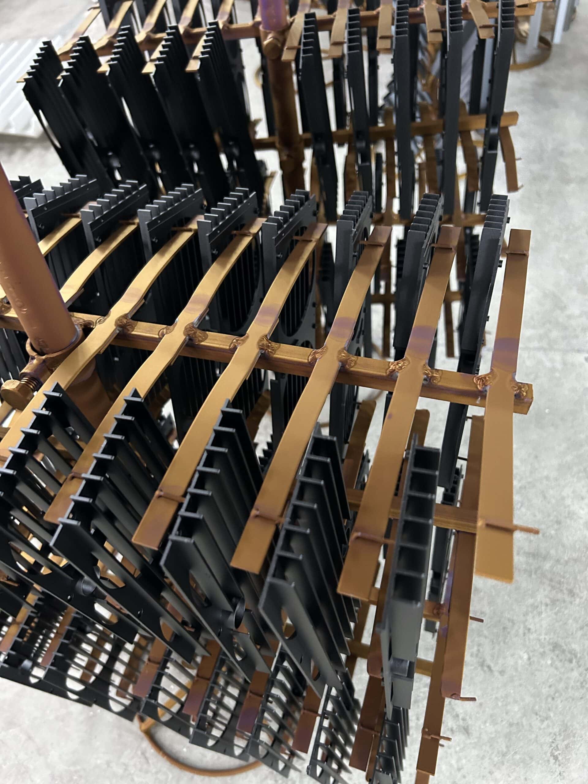 Black anodized aluminum heat sinks hanging on finishing racks