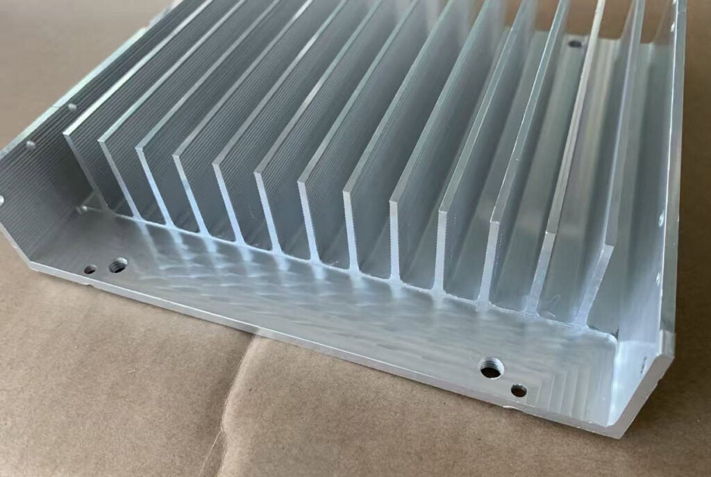 CNC machined extruded aluminum heat sink with mounting holes and tall cooling fins